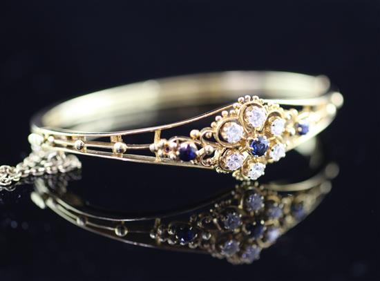 An 18ct gold, diamond and sapphire set hinged bangle, 2.75in.